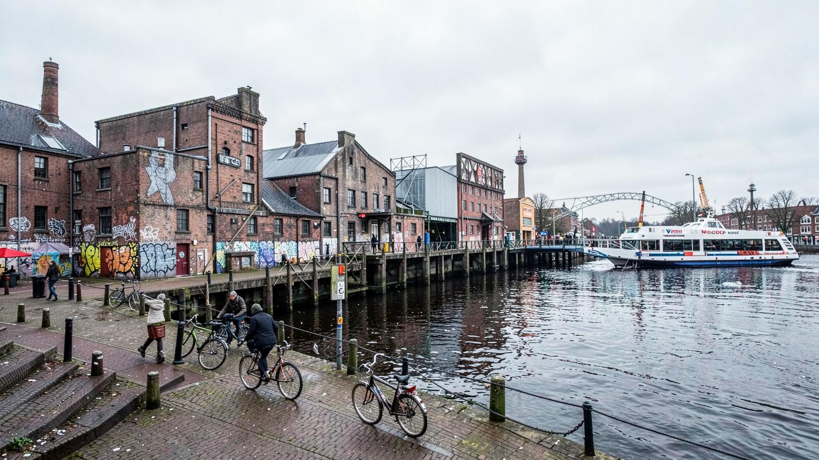 View across the IJ river towards the industrial cranes and warehouses of NDSM wharf in Amsterdam Noord