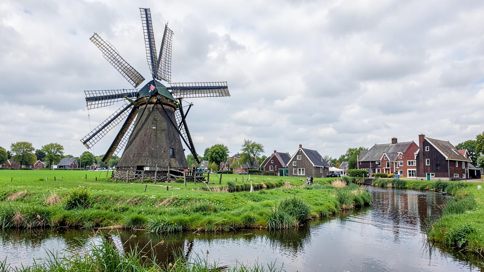 Traditional windmills at Zaanse Schans reflected in the water near Amsterdam